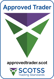 A badge with the text Approved Trader at the top, a green and purple geometric logo in the center—ideal for trusted uPVC windows Perth or doors experts—and approvedtrader.scot above the SCOTSS Trading Standards logo at the bottom.